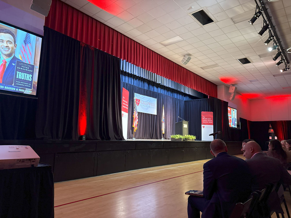 University speaker series AV production with stage lighting projection screens and audience New Jersey